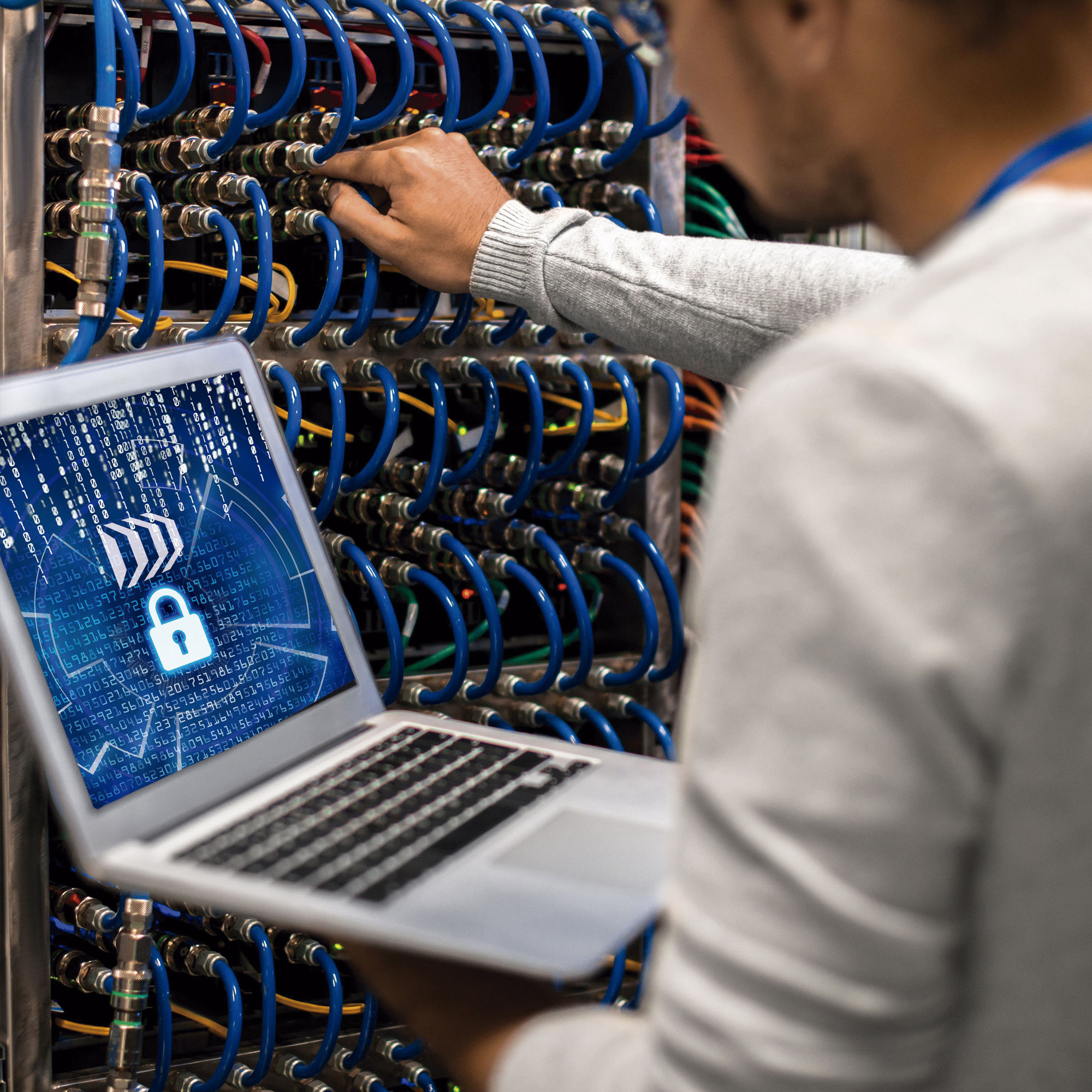 SOC de seguridad Analista de ciberseguridad en un SOC monitoreando servidores y red segura desde portátil con sistema de protección de datos.